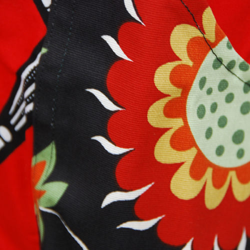 Tablier en très belle wax d'un beau rouge avec motifs 'ombrelles' en noir et blanc avec poches aux motifs floraux sur fond noir.