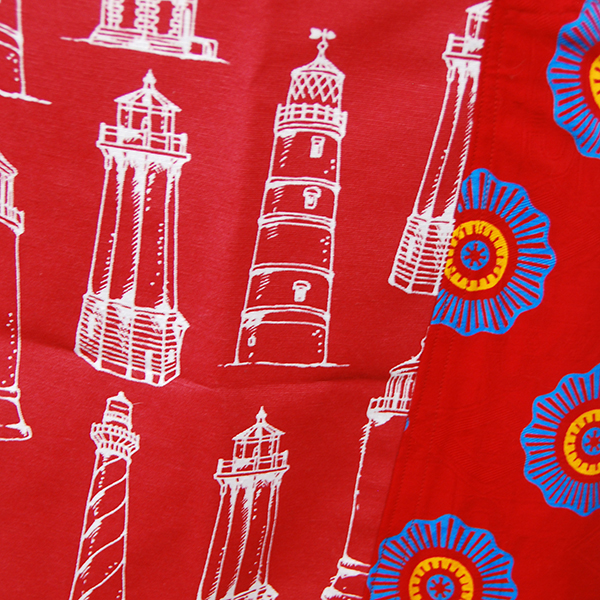 tablier rouge à motifs de phares avec poche en wax rouge à motifs bleus.